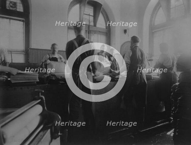 Workers wetting sheets prior to printing paper money at the Bureau of Engraving & Printing, c1895. Creator: Frances Benjamin Johnston.