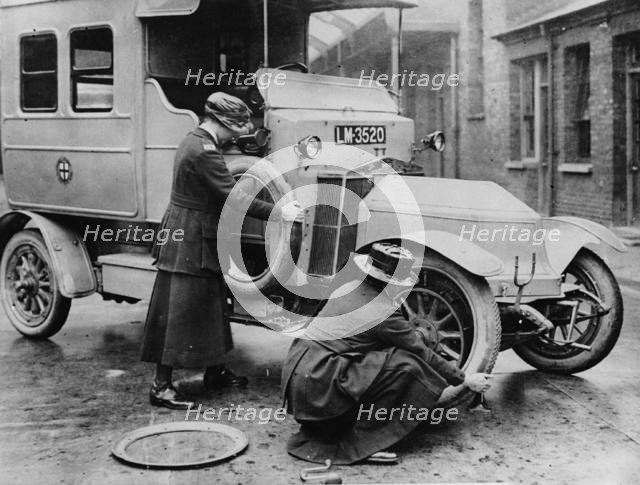 Siddeley Deasy ambulance 1911, women changing wheel. Creator: Unknown.