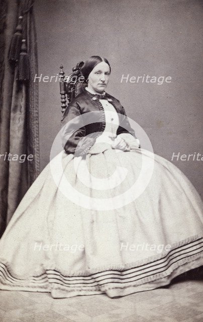 Studio portrait of a young woman in an ankle-length dress, late 19th century(?). Artist: Unknown