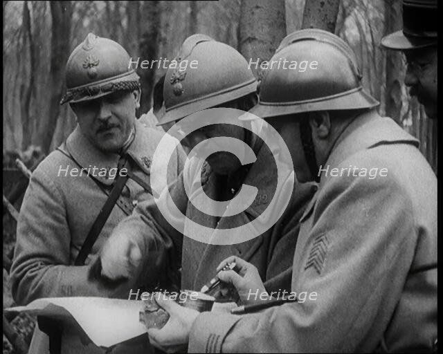 Three Male French Soldiers Standing in a Wood Looking at a Map, 1924. Creator: British Pathe Ltd.