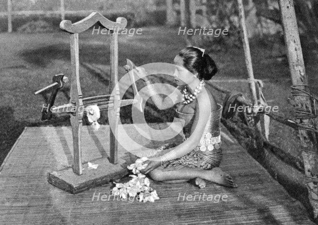 Iban woman making thread with a mangle, Borneo, 1922. Artist: Dr Charles Hose