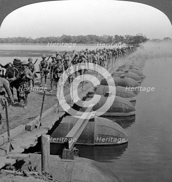 Machine gun section and infantry crossing a pontoon bridge, World War I, 1914-1918.Artist: Realistic Travels Publishers