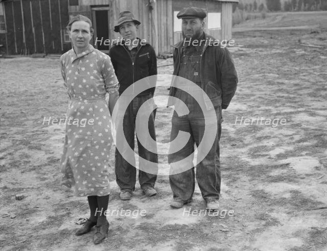 The mother, father, and hardworking fifteen-year-old son in yard..., Boundary County, Idaho, 1939. Creator: Dorothea Lange.