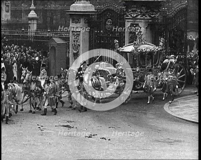 The Royal Coach, Horses, and Procession Filing Out of the Gates at the Front of Buckingham..., 1937. Creator: British Pathe Ltd.