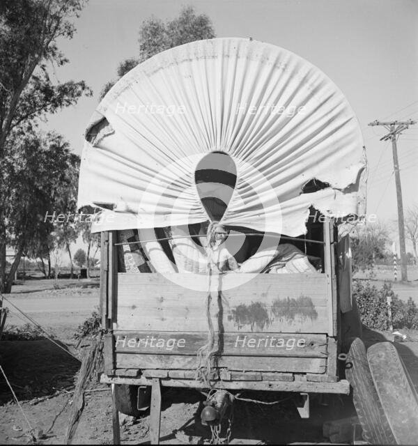 Covered wagon, migratory carrot puller's camp, near Holtville, Imperial Valley, 1939. Creator: Dorothea Lange.