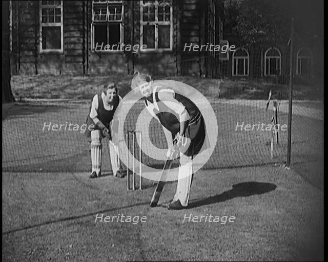 Two Female Civilians Wearing Gymslips and Batting Pads Preparing to Bat in a Playing Field, 1920. Creator: British Pathe Ltd.