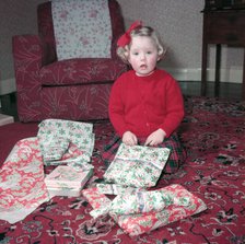 Girl opening her Christmas presents, c1955.  Creator: Arthur Charles Kirby Ware.