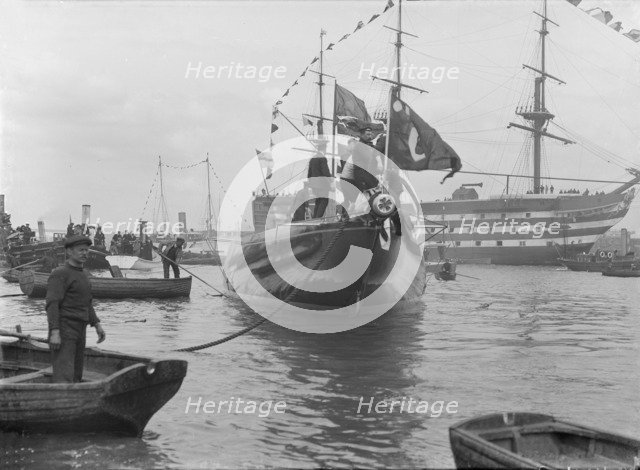 After launch of 'Shamrock IV' at Gosport with H.M.S. Victory in the background, May 1914. Creator: Kirk & Sons of Cowes.