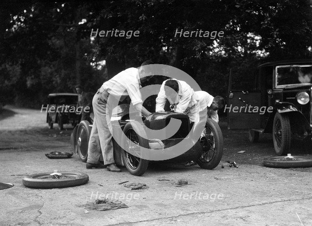 Mechanics working on Leon Cushman's Austin 7 racer for a speed record attempt, Brooklands, 1931. Artist: Bill Brunell.