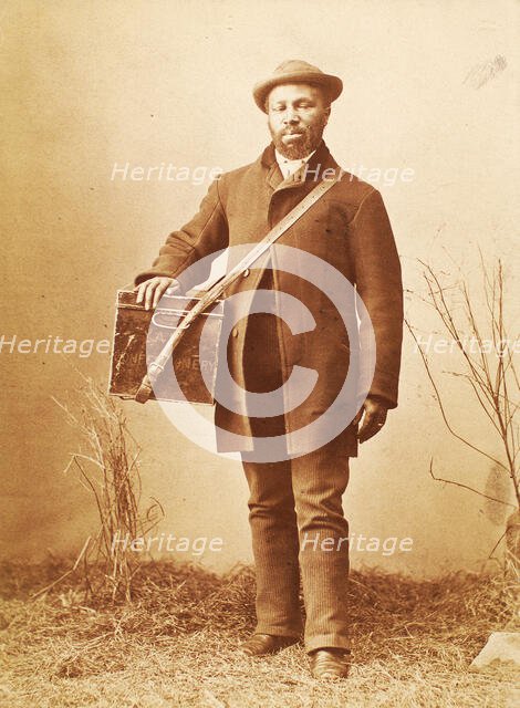 Studio portrait of man holding box labelled 'Confectionery', c1880. Creator: William Notman.