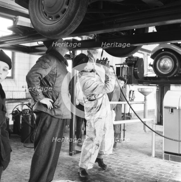 Tyre lubrication of passenger car, Stockholm, Sweden, 1955. Creator: Unknown.