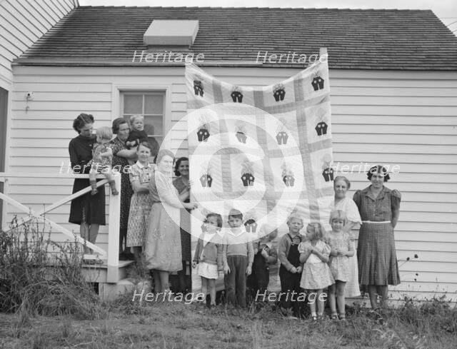 Farm women of the "Helping Hand" club display a pieced quilt..., near West Carlton, Oregon, 1939. Creator: Dorothea Lange.