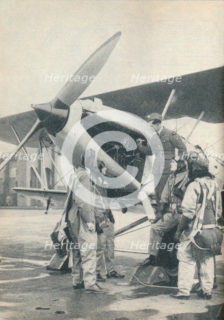 An instructor explaining engine details to a pupils at Sealand Aerodrome, Flintshire, c1936 (c1937). Artist: Unknown.