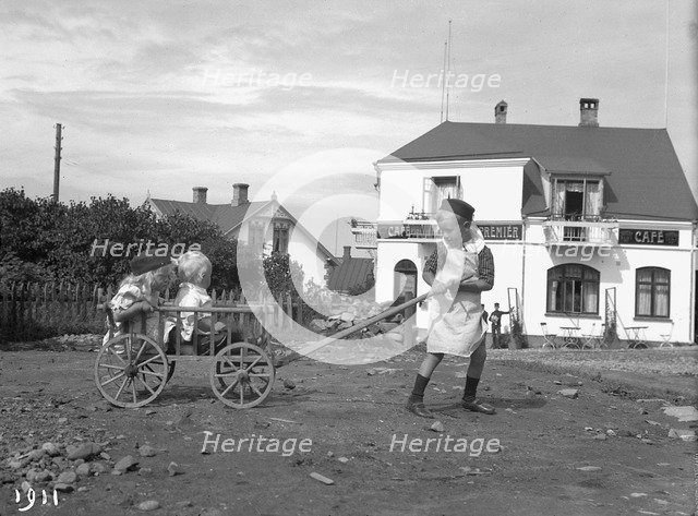 A boy pulling his brother and sister in a cart, 1911. Artist: Unknown