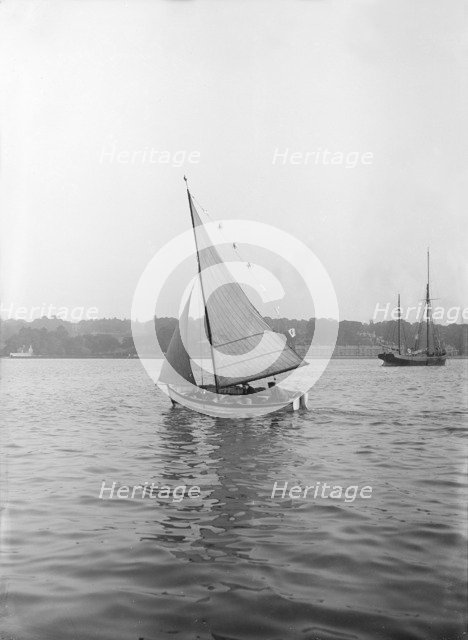 The sailing dinghy 'Hound' with flags, 1912. Creator: Kirk & Sons of Cowes.