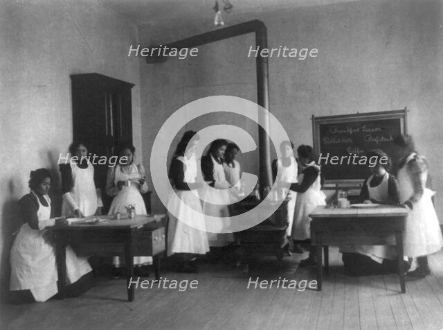 Breakfast lesson in home economics class for women. Carlisle Indian School, Pa., 1901. Creator: Frances Benjamin Johnston.