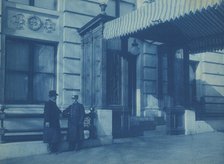 Two men, one a doorman, standing at the F. Street entrance to the Willard..., between 1901 and 1910. Creator: Frances Benjamin Johnston.
