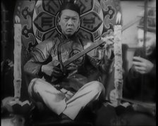 Scene from the Film 'Piccadilly': Male Actor Playing a Lute, 1920s. Creator: British Pathe Ltd.