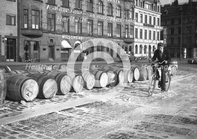 Cyclist riding through evaporated milk spilt from barrels on the quayside, Malmö, Sweden, May 1947. Artist: Otto Ohm
