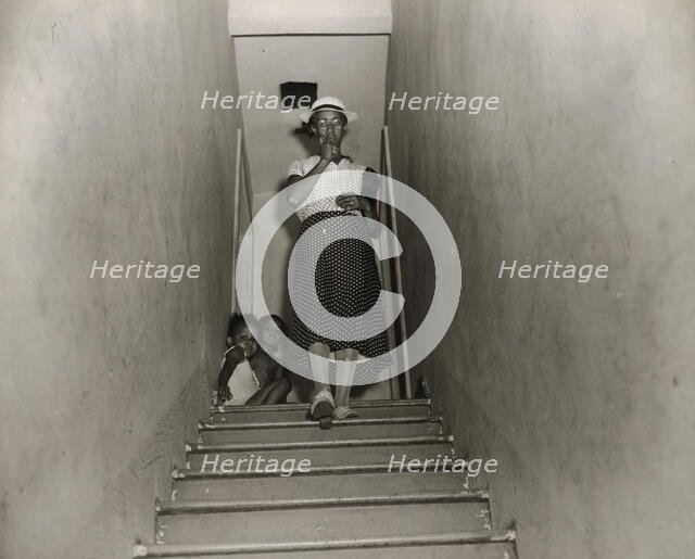 Mrs. Ella Watson, a government charwoman, leaves for work at 4:30 p.m., Washington, D.C., 1942. Creator: Gordon Parks.