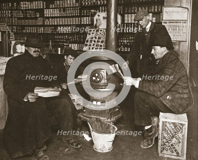 A group of men around a stove in a shop, USA, c1910. Artist: Unknown