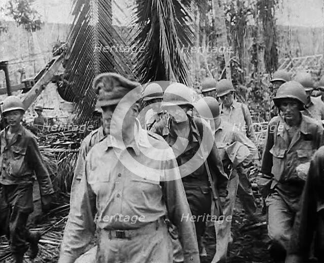General Douglas MacArthur Walking With American Troops Through Jungle in the Pacific Campaign, 1943. Creator: British Pathe Ltd.