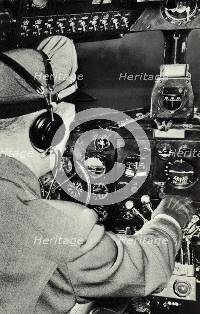 Pilot in the cockpit of a Douglas DC-3 aeroplane, 1940. Artist: Unknown