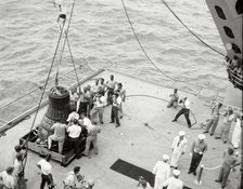 Gordon Cooper and capsule on deck, Pacific Ocean, 1963.  Creator: NASA.