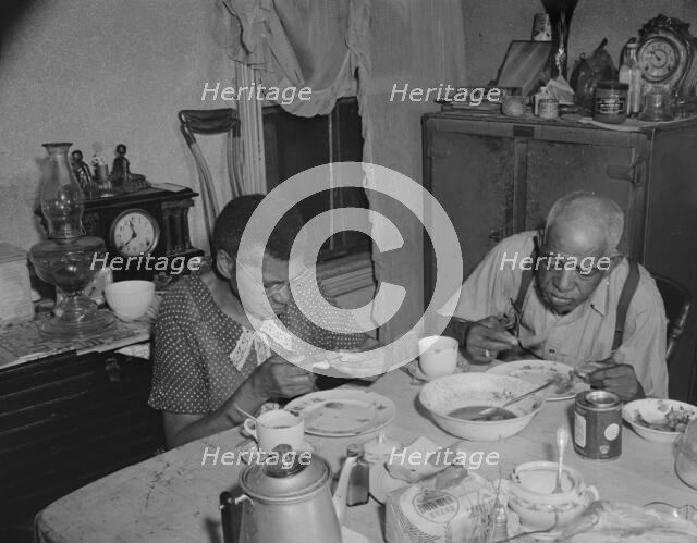 Elderly couple eating dinner at their home on Lamont Street, N.W., Washington, D.C., 1942. Creator: Gordon Parks.
