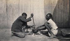 Umtali, Zimbabwe: two African boys stirring a cooking pot, 1905. Creator: J Lomas.