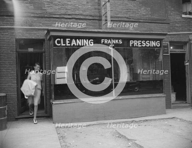 Possibly: A tailor in Frank's cleaning and pressing establishment checking..., Washington, DC, 1942. Creator: Gordon Parks.