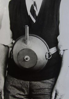 Cecil Vandepeer Clarke wearing an early version of the limpet mine on a keeper plate, c1939.  Creator: British Government.