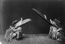 Kotsuis and Hohhug-Nakoaktok, wearing ceremonial dress, with long beaks, on their haunches..., c1914 Creator: Edward Sheriff Curtis.