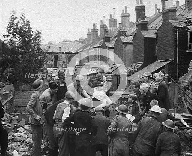 An Injured Child Being Carried from a Bombed Out House, 1940. Creator: British Pathe Ltd.