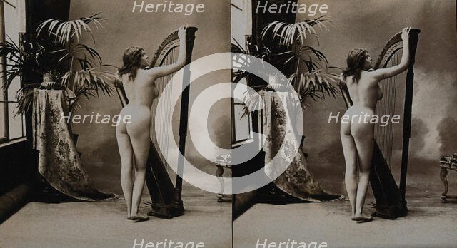 A young woman posing naked in a photographic studio, standing with her back to the camera..., c1900. Creator: Unknown.