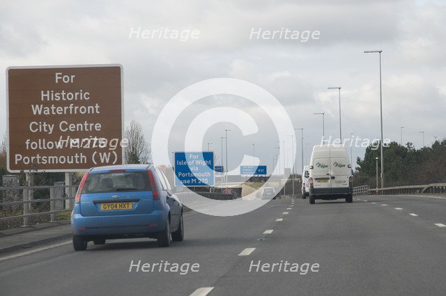 Traffic on M27 Motorway with brown tourist information sign
