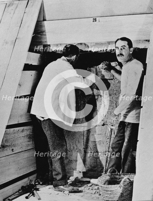 Howard Carter and a colleague excavating a tomb in the Valley of the Kings, Egypt, 1922. Artist: Harry Burton