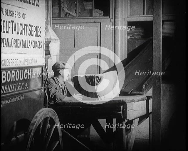 A Man Loading Bundles of Newspapers Into a Van, 1921. Creator: British Pathe Ltd.
