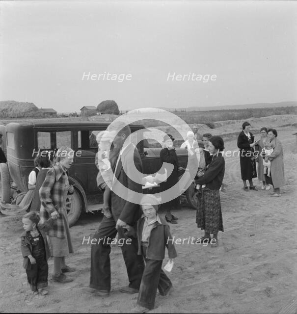Congregation leaving after services, preacher in doorway, Dead Ox Flat, Oregon, 1939. Creator: Dorothea Lange.