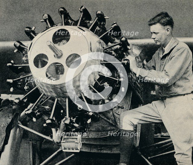 Charles Lindbergh checking the engine of his aircraft before his transatlantic flight, 1927 (c1937). Artist: Unknown.