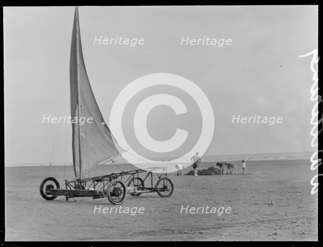 A sand yacht on West Wittering Beach with people digging in the sand, Chichester, West Sussex, 1930s Creator: George R Long.