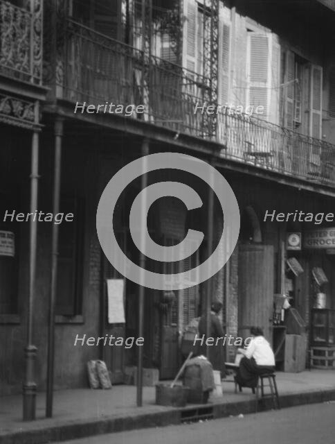 Women on a covered sidewalk, New Orleans, between 1920 and 1926. Creator: Arnold Genthe.