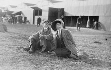 Mrs. Payne Whitney with unidentified gentleman seated on flying field of aviation meet, 1910. Creator: Bain News Service.