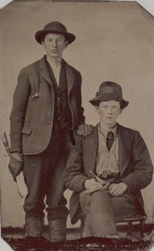 Two Young Men, One Seated and One Standing, Holding Carpentry Tools, 1870s-90s. Creator: Unknown.