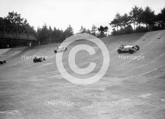 Invicta, Talbot and Frazer-Nash cars racing on the Members Banking at Brooklands. Artist: Bill Brunell.