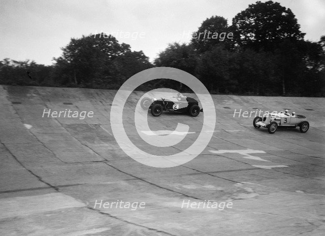 Invicta and Vauxhall 30/98 racing on the banking at an Inter-Club Meeting, Brooklands, 20 June 1931. Artist: Bill Brunell.