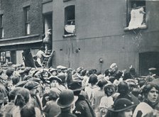 Crowd watching the looting of a German house in Poplar, c1914. Artist: Unknown