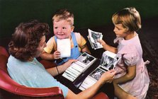 A mother and children looking at photos in a family album, Blackwood, New Jersey, USA, 1956. Artist: Unknown