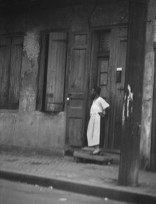 Woman standing in a doorway in the French Quarter, New Orleans, between 1920 and 1926. Creator: Arnold Genthe.