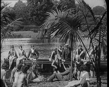 A Group of Young Civilians Wearing Swimsuits Seating on a Boat on Riverside, 1920. Creator: British Pathe Ltd.